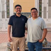 Dos escolares jesuitas abrazados mirando al frente
