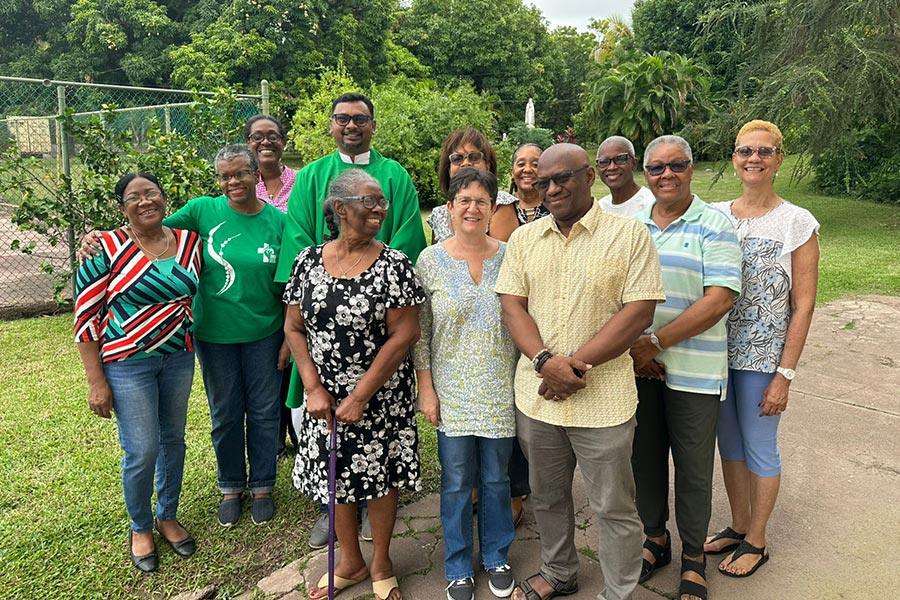 Grupo de mujeres y hombres mayores junto a sacerdote jesuita