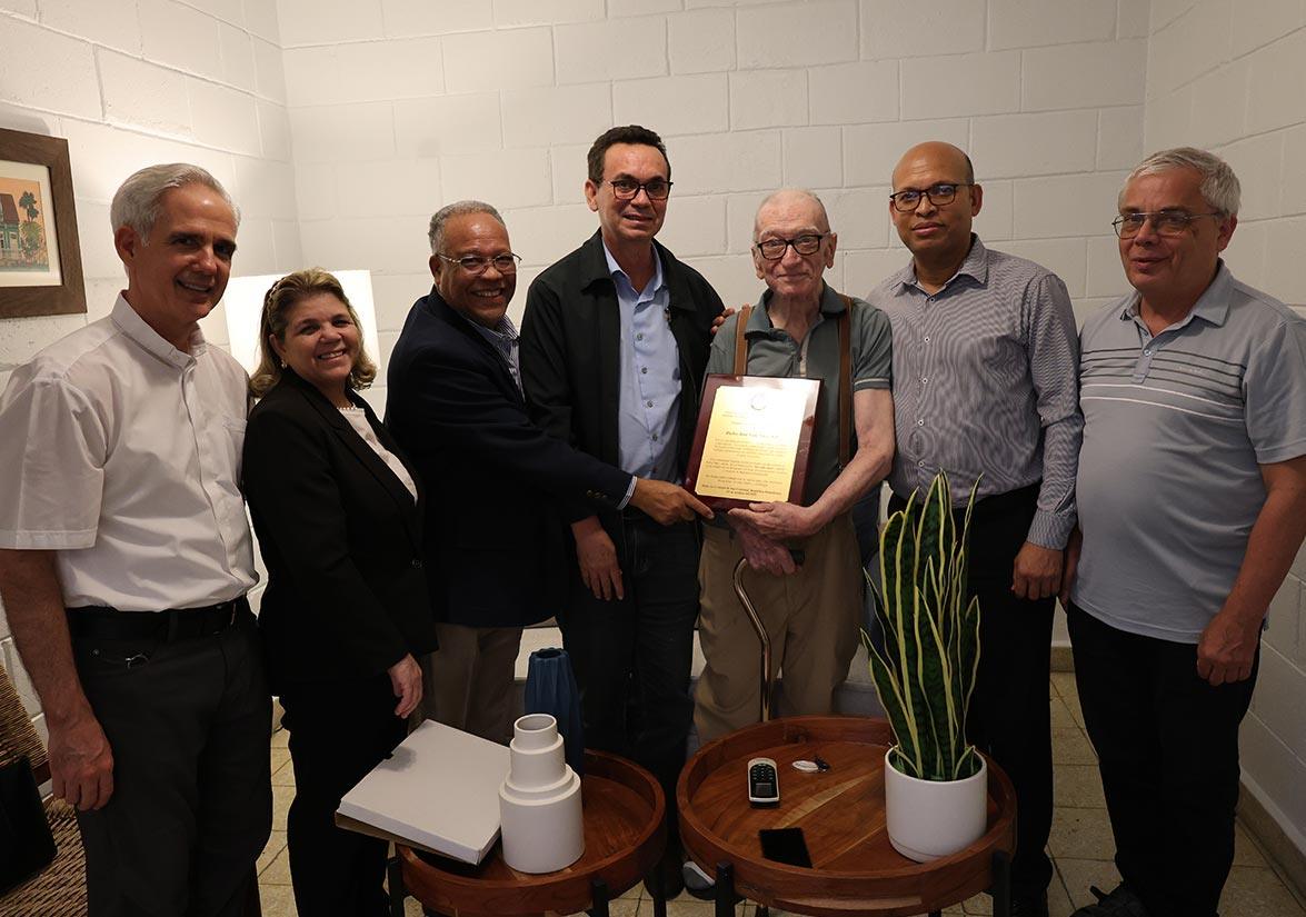 Grupo de jesuitas homenajeando a sacerdorte jesuita anciano