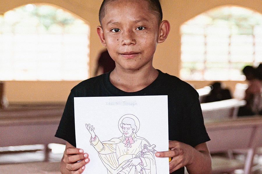 Niño sosteniendo dibujo de San Jose de Anchieta